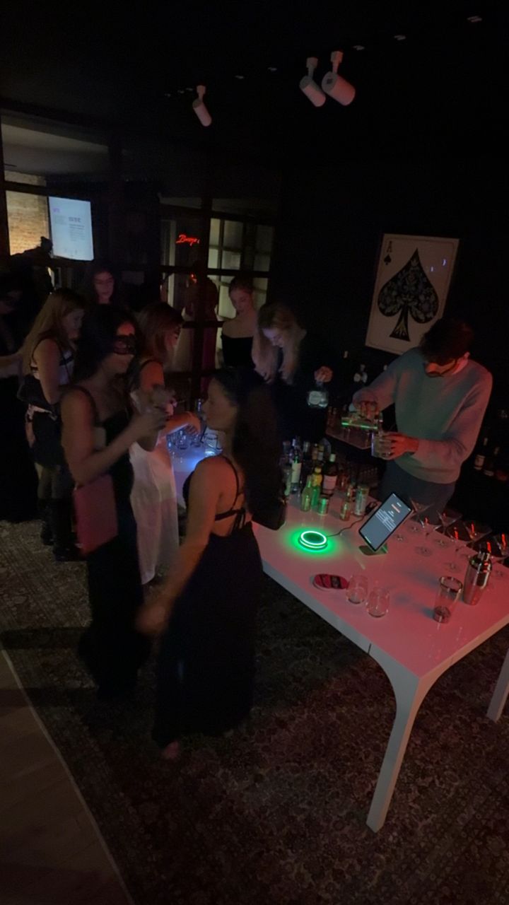 Guests at a Barsys private event, AI cocktail machine glowing at the bar